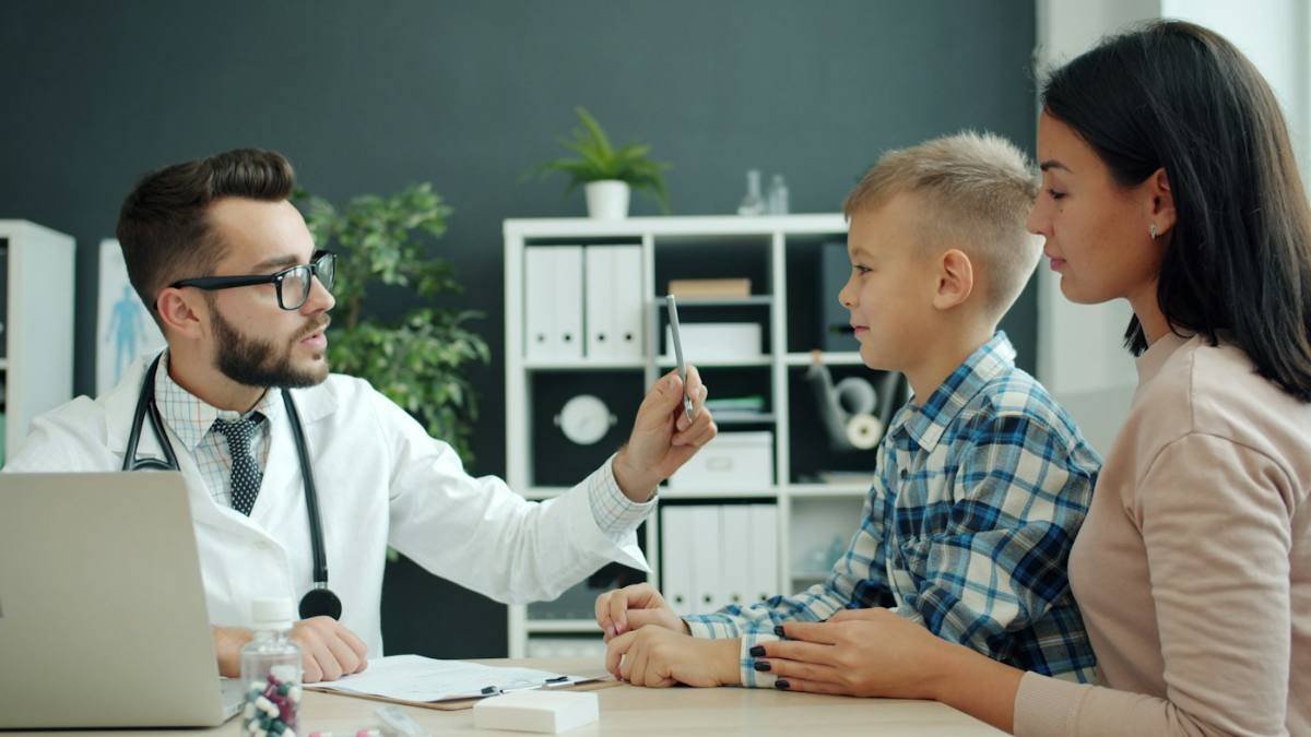 Médico atendendo criança com a mãe